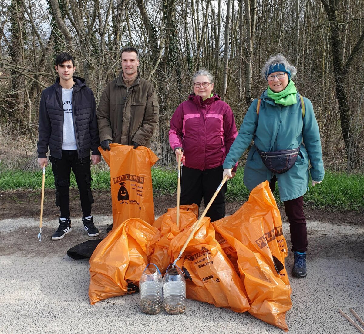 Vier Sammlerinnen und Sammler mit Müllsäcken und Behältern mit aufgelesenen Kippen. 