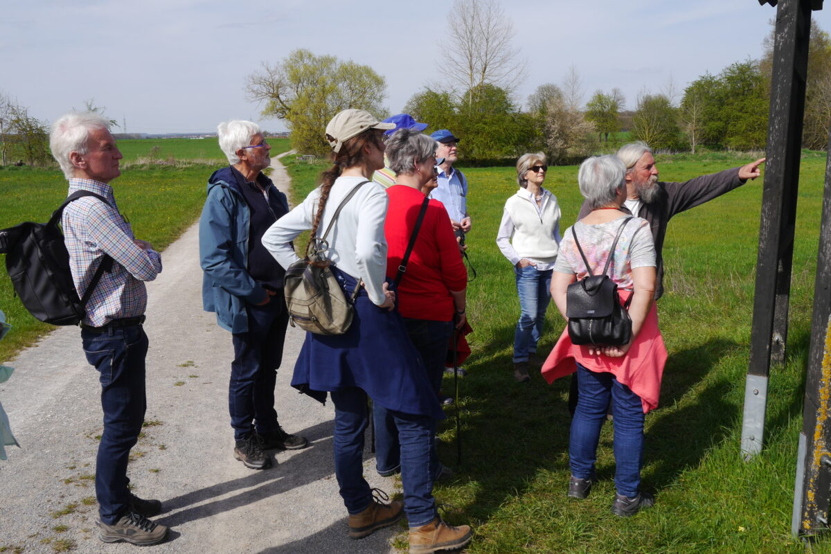 Die Teilnehmer*innen der Wanderung zum Gipshügel hören Herrn Herr Rößner zu, während er Spannendes über die Landschaft erklärt.