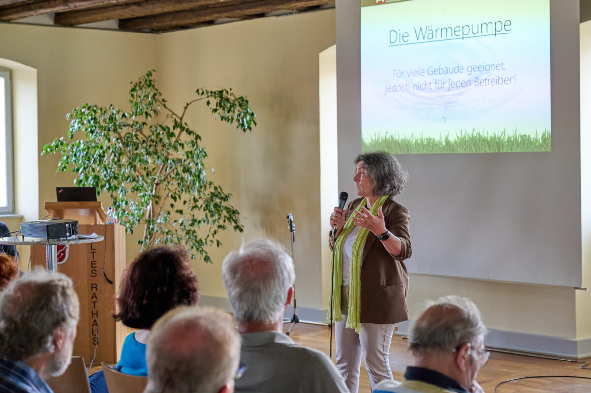 Foto von Kerstin Celina mit Mirko in der Hand, im Hintergrund eine Powerpointpräsentation