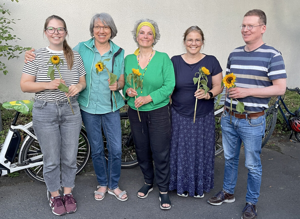 Die 5 Vorstände, stehend mit Sonnenblumen in der Hand.
V.l.n.r.: Theresa Kunzelmann (Beisitzerin), Brigitte List-Gessler (Vorsitzende), Beatrix Radke (Vorsitzende), Stefanie Hauser (Beisitzerin) und Gregor Wolf (Beisitzer)