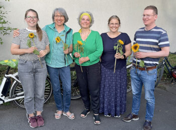 Fotografie der fünf neu gewählten Vorständen. In ihren Händen halten alle fünf Sonnenblumen und lächeln in die Kamera