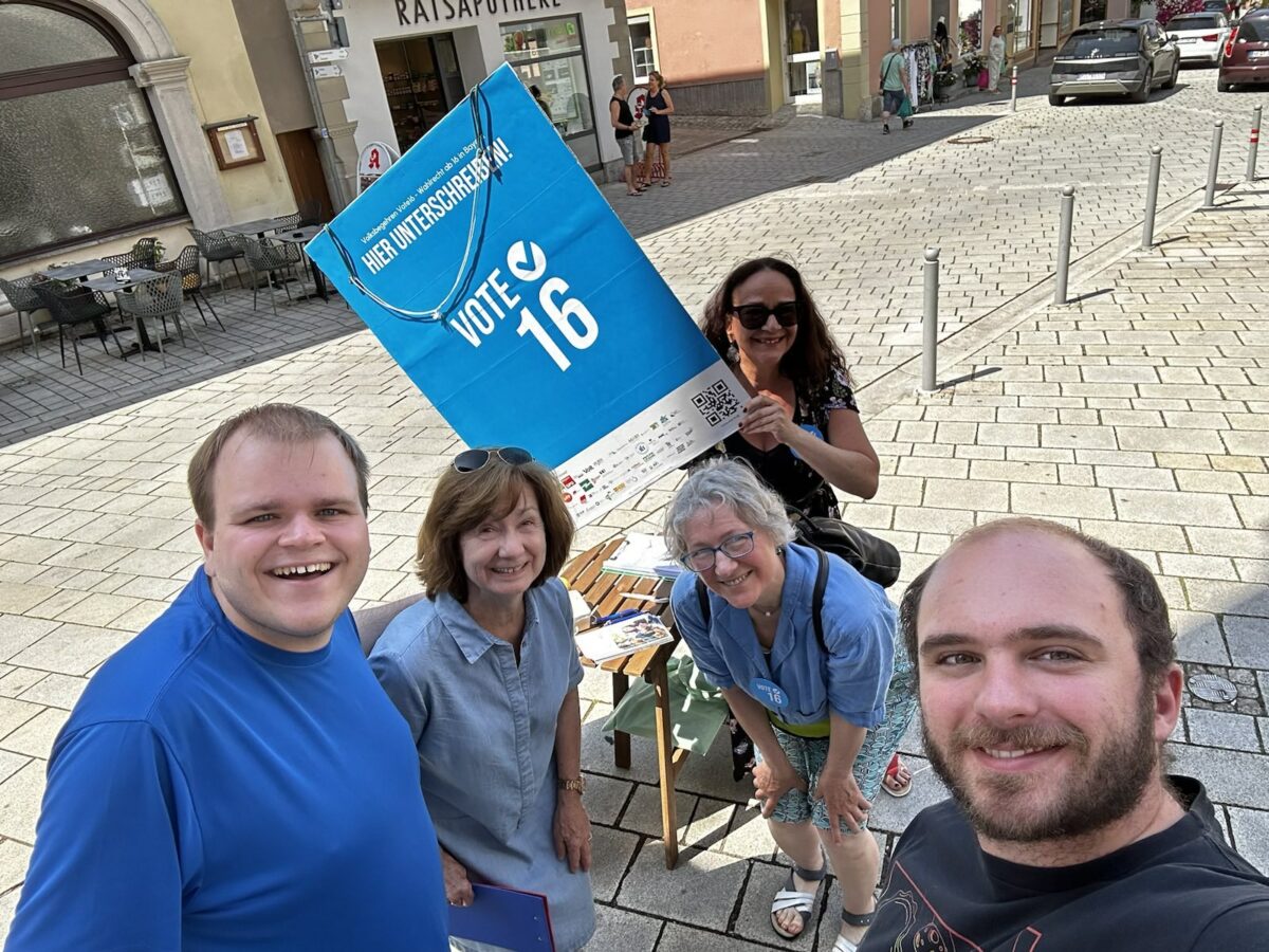 Selfie von fünf Personen - Die fleißigen Unterschriftensammler*innen aus Ochsenfurt mit einem Plakat. 