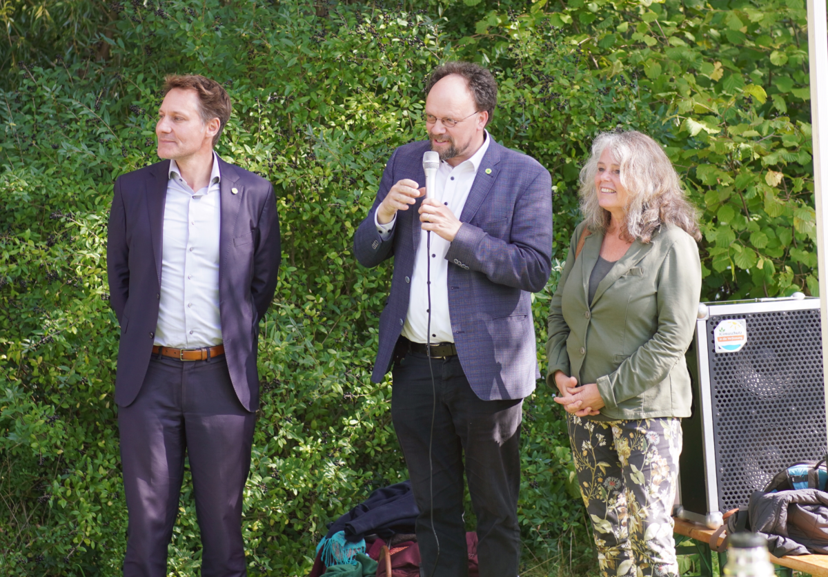 Zu sehen sind Ludwig Hartmann, Patrick Friedl und Christina Feiler. Patrick Friedl hält eine Rede.