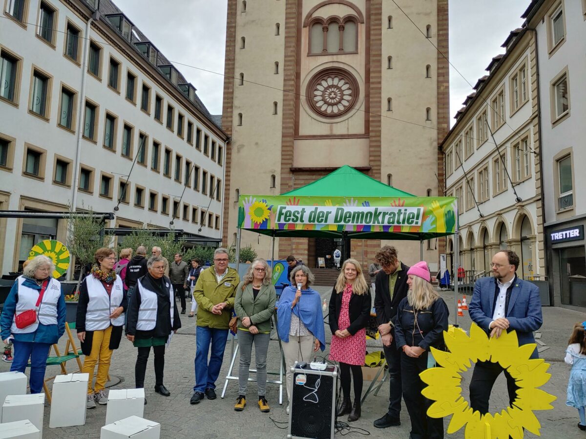 Ein Bild vom Fest der Demokratie. Im Hintergrund ist die Domkirche und ein Pavillon mit der Aufschrift "Fest der Demokratie" zu erkennen. 