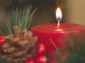 Sharpic mit einer roten brennenden Kerze in einem Weihnachtsgesteck. Dazu die Infos der Veranstaltung und das Grüne Sonnenblumenlogo
