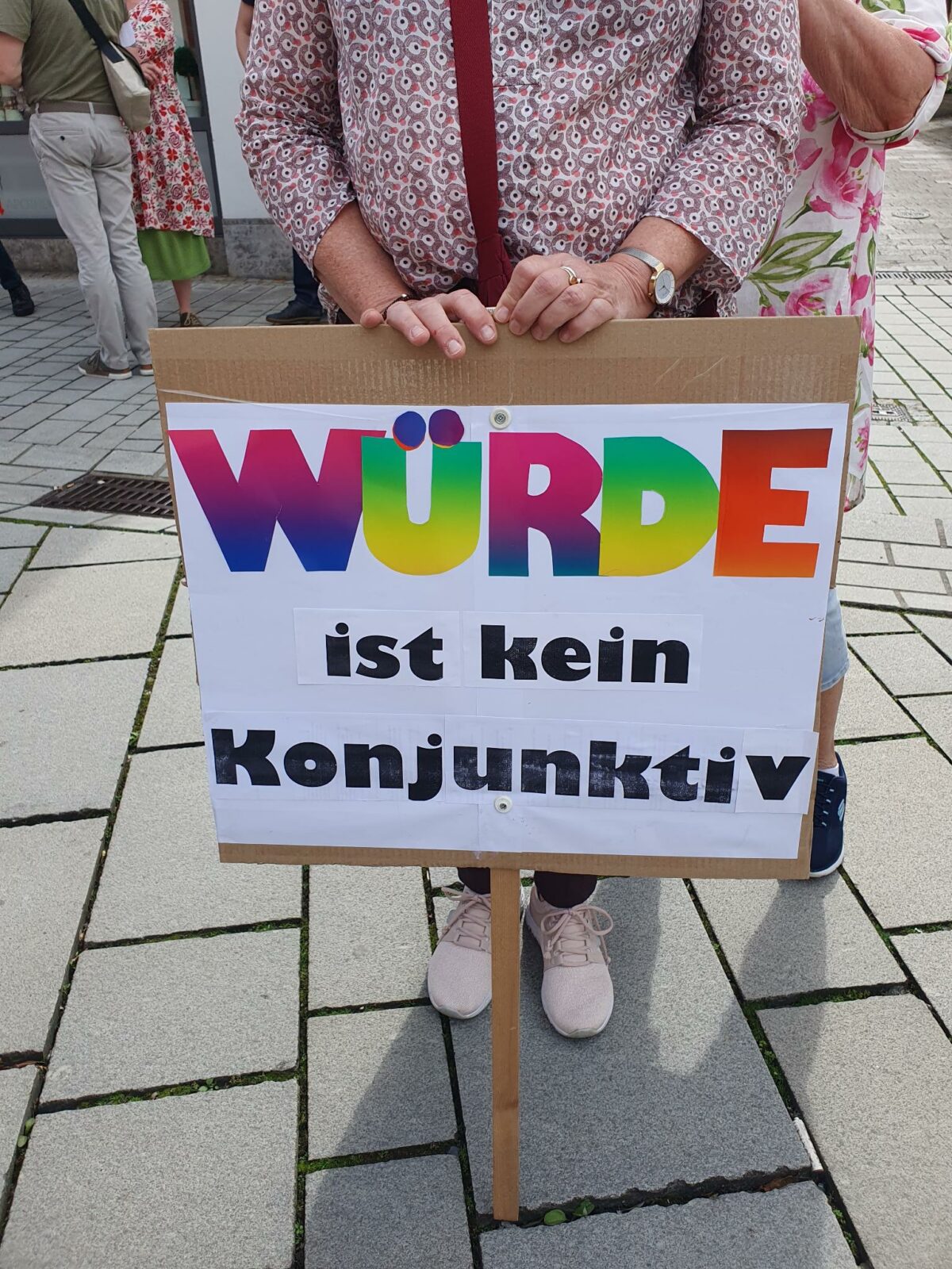 Foto von einem selbstgebastelten Plakat mit der Aufschrift "Würde ist kein Konjunktiv"